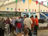 Photo of flags, people and the bar inside the tent.